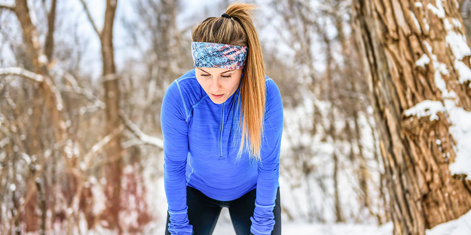 Jogger catching her breath in a wintery scene.