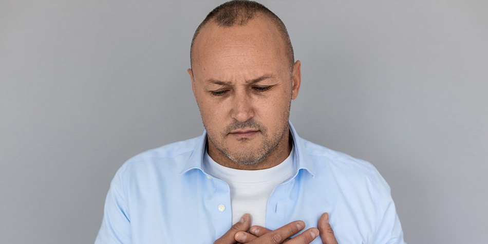 Man with hands on his chest in slight discomfort.