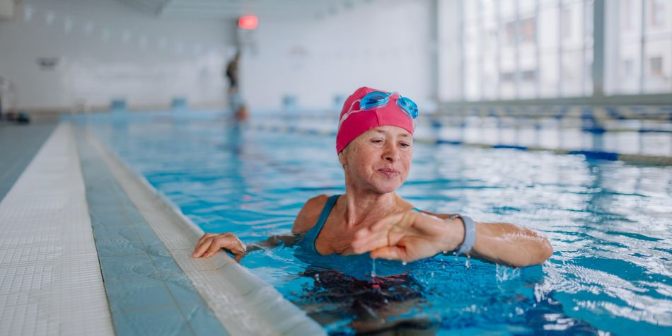 Mature woman in swimming pool checking her fitness watch